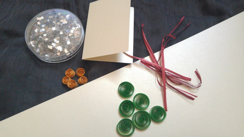 Green paper circles, small orange paper circles, an empty gift tag and silver stars