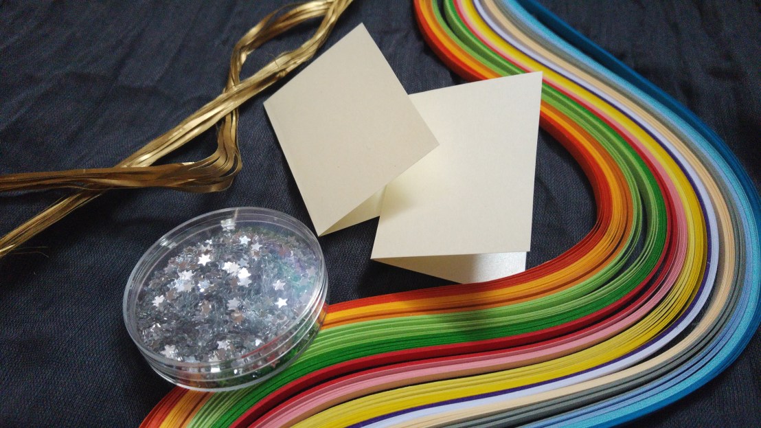 Two empty gift tags, colourful paper strips and silver stars