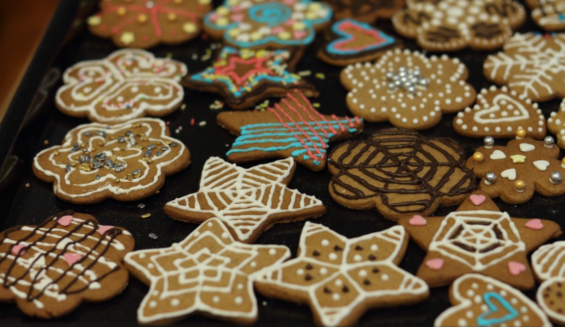 Multiple gingerbread cut out cookies decorated with coloured icing and chocolate