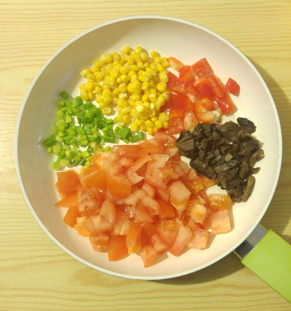 Chopped up vegetables for the omelette on a frying pan