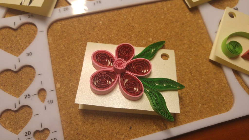 A handmade gift tag - red and pink flower with leaves