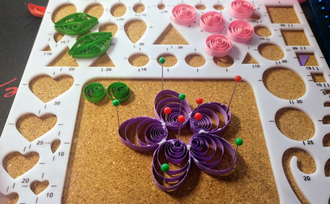 A purple quilling flower in progress