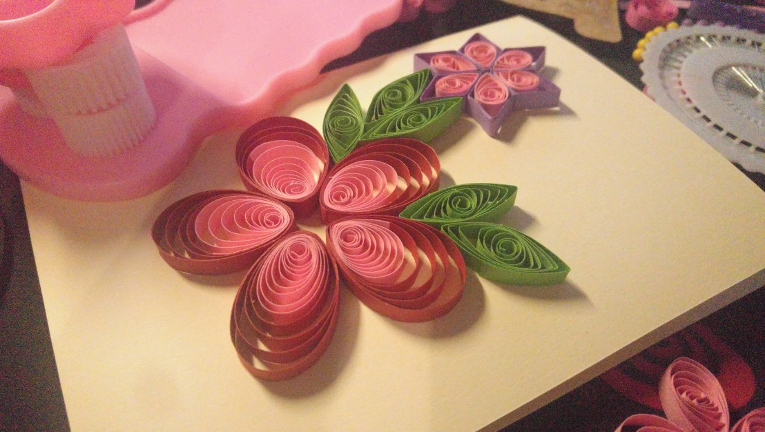 A handmade quilling card in progress - red and pink flower