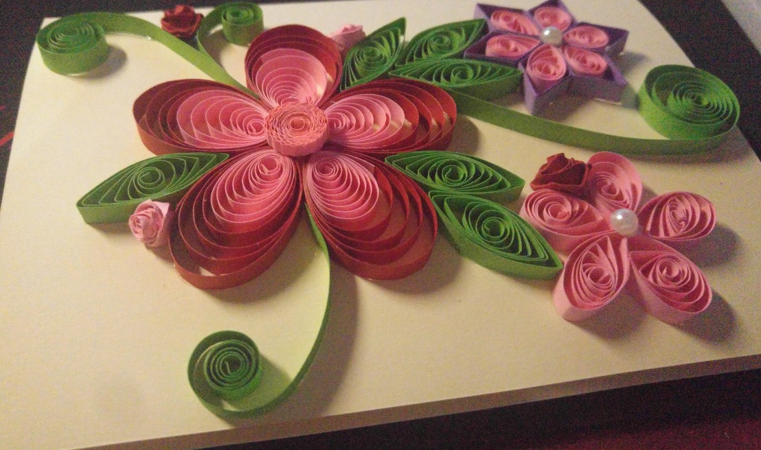 A handmade quilled card - red, pink and purple flowers