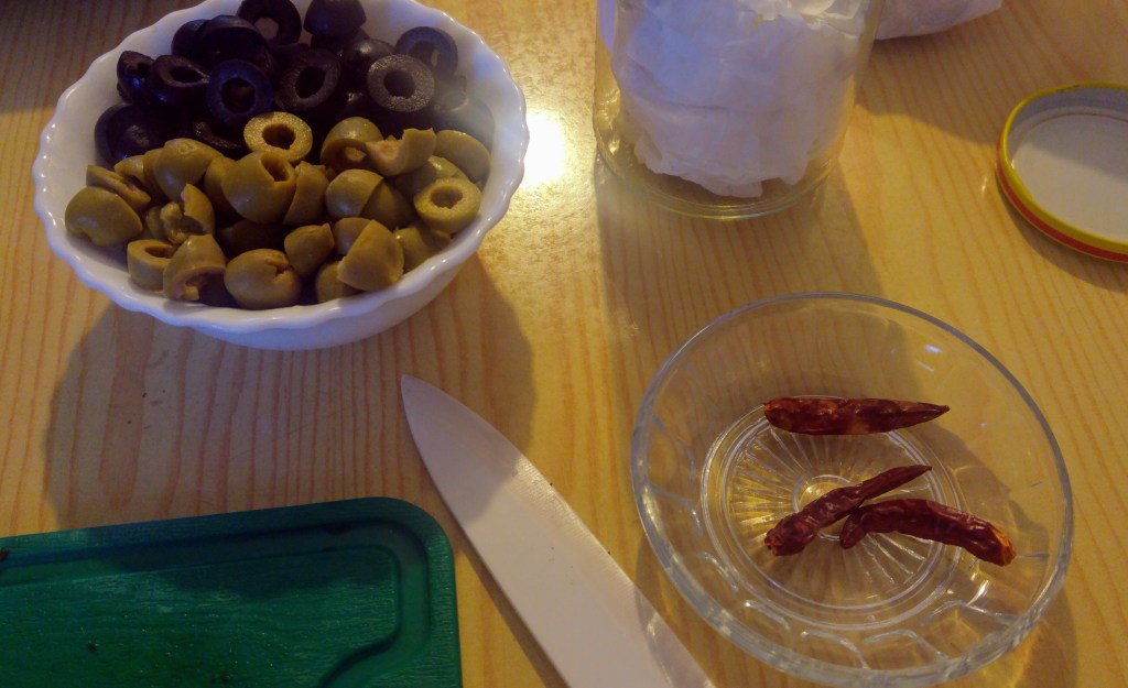 Ingredients for a thick crust pizza - olives and chillis
