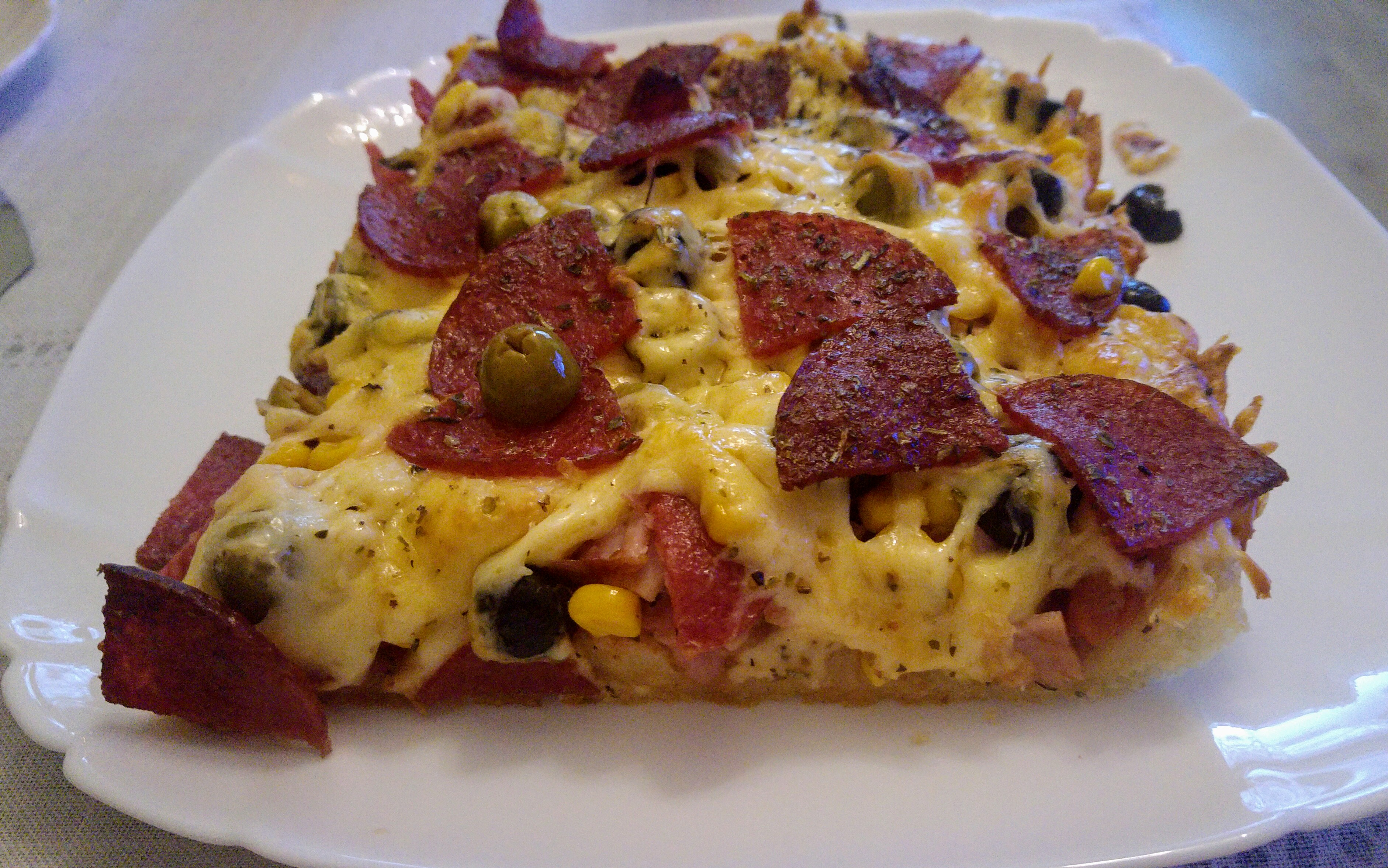 Slice of baked thick crust pizza