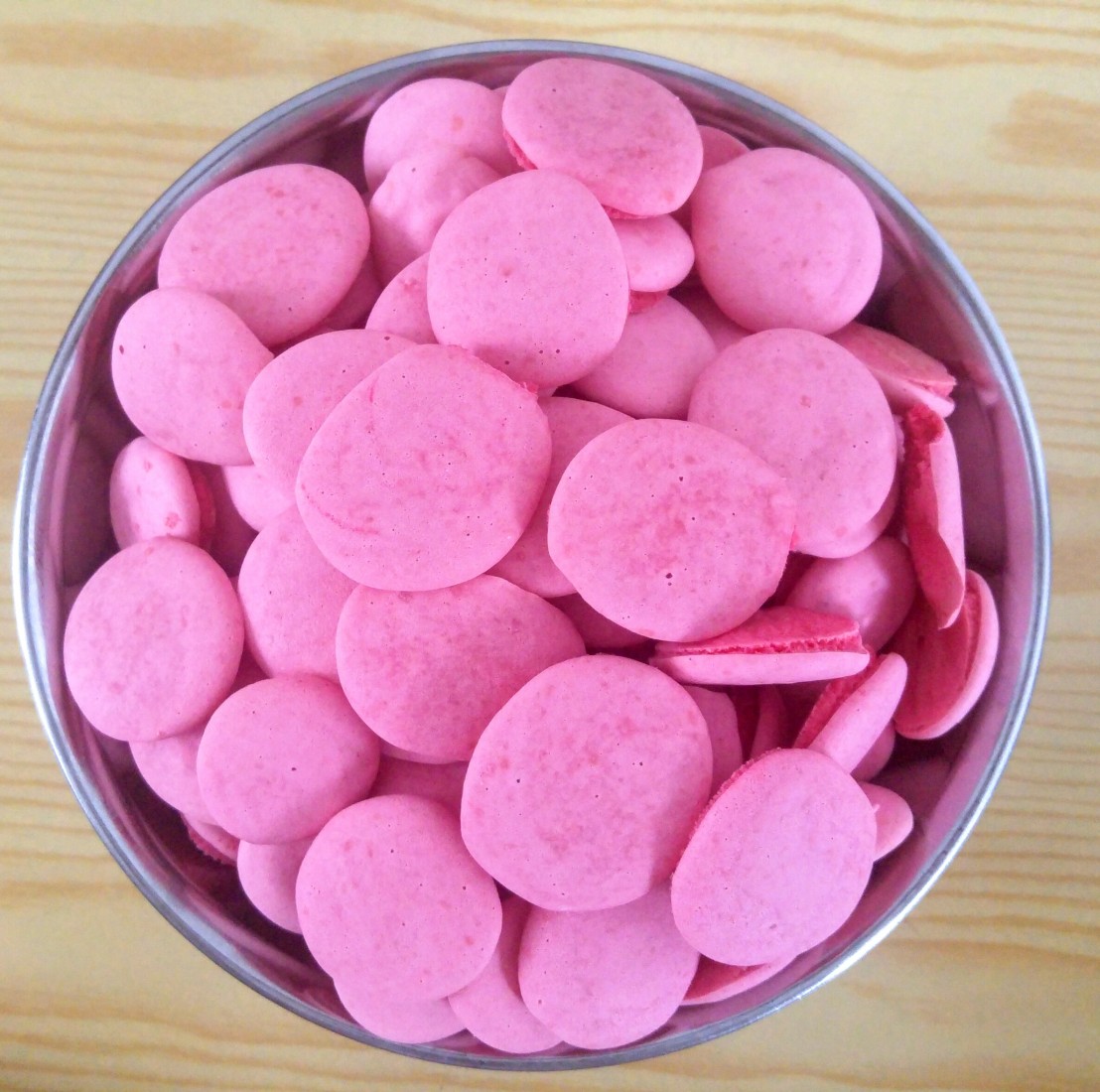 Small, round pink cookies in a metal bowl