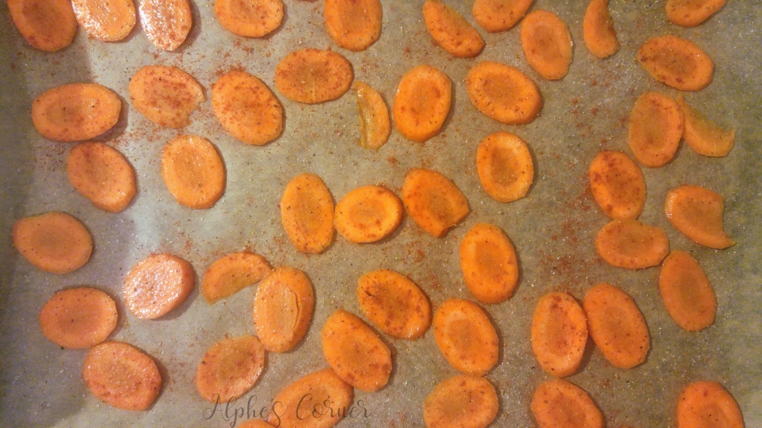 Sliced carrot with seasoning, on a baking tray