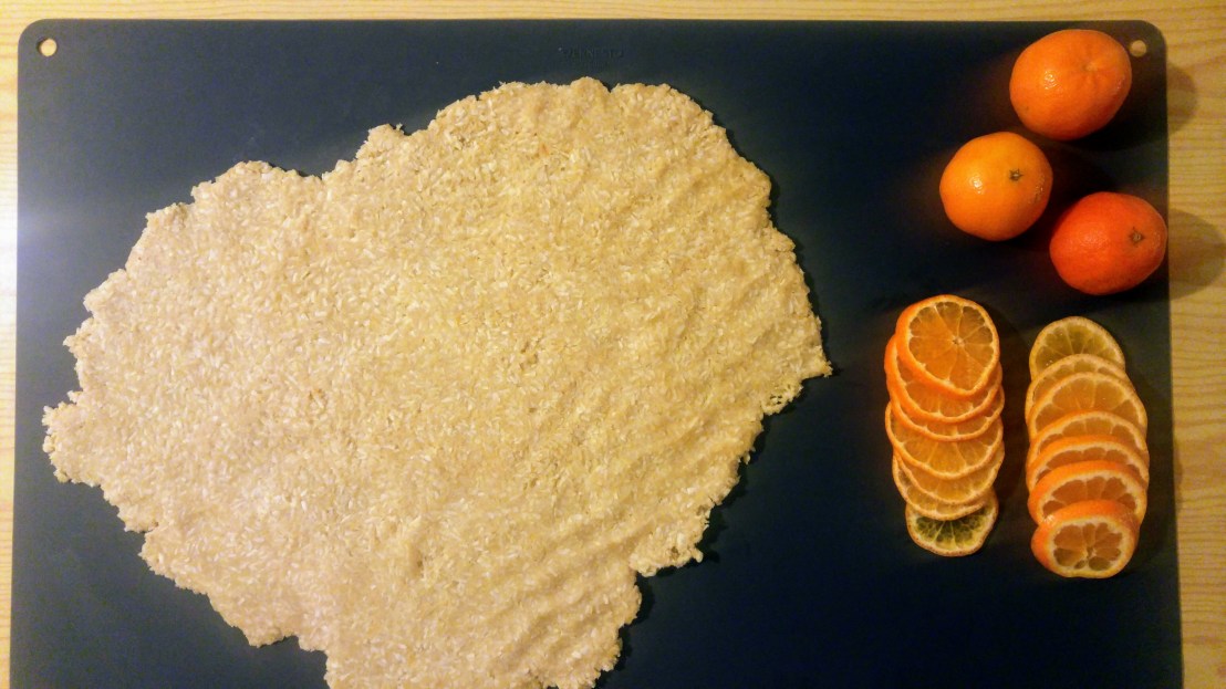 Rolled out cookie dough and sliced tangerines