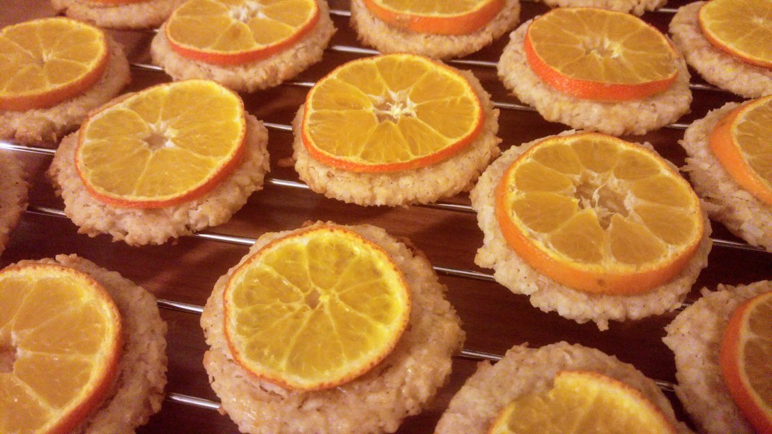 Baked cookies with slices of tangerine, on a cooling rack