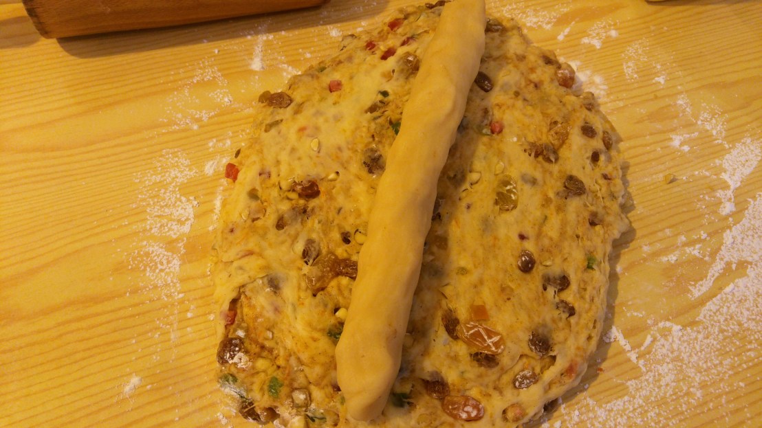 Rolled out dough for Christstollen with marzipan on top