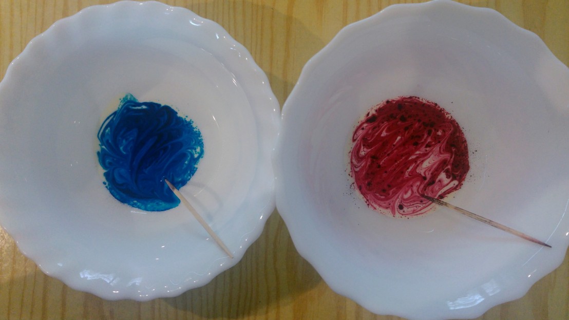 Two bowls with food dye dissolved in double cream