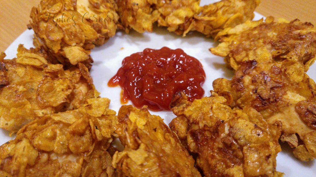 Corn Flakes chicken nuggets with ketchup, on a plate