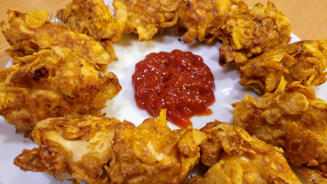 Corn Flakes chicken nuggets on a plate, with ketchup