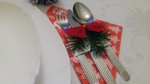 DIY Christmas cutlery bands on the table, next to a plate