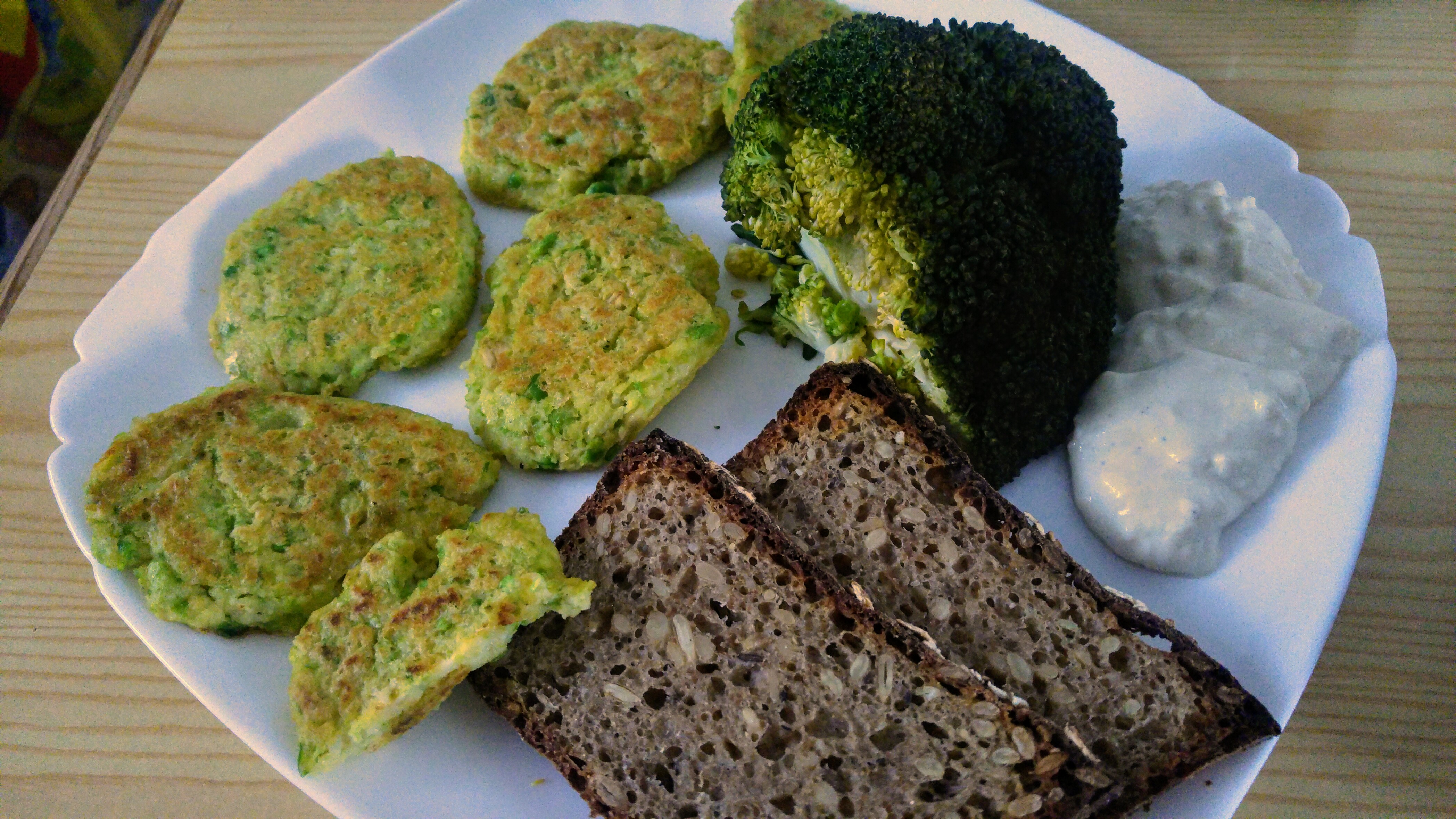 Green peas millet patties on a plate, with broccoli, sourdough bread and garlic sauce