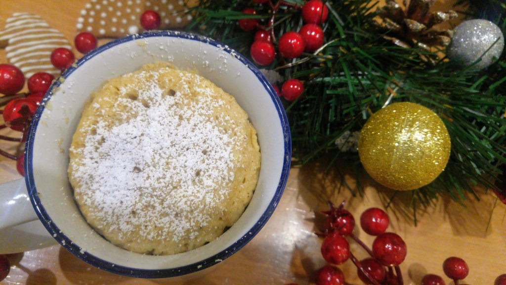 A baked gingerbread mug cake and Christmas decorations