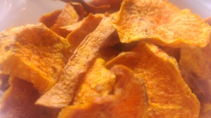 A close up on baked sweet potato crisps in a bowl
