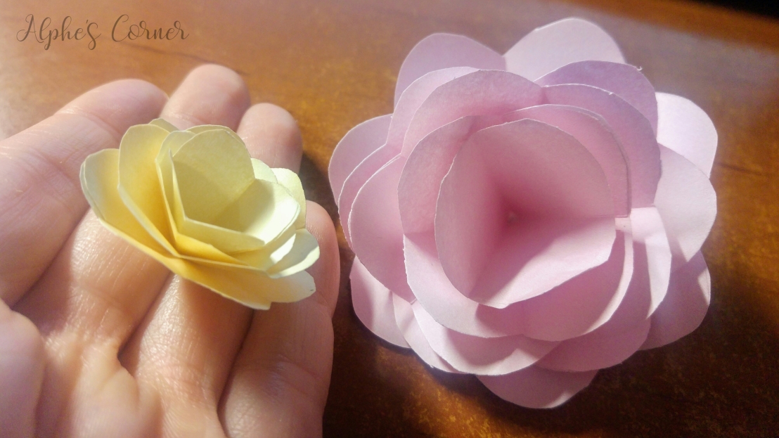 Holding paper roses: yellow and pink