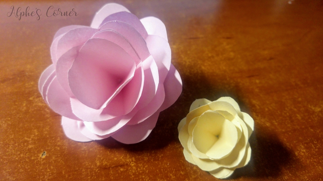 Two completed paper roses: pink and yellow