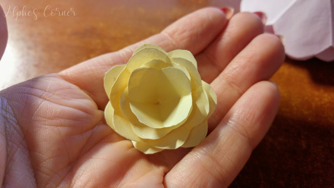 Holding a small yellow paper rose