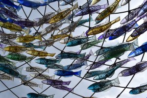 A painting of a bunch of yellow, blue and green fish