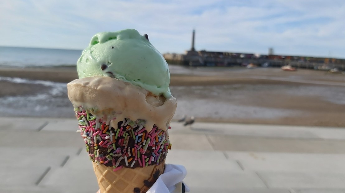 Ice cream in a cone with chocolate and sprinkles, on the Margate beach