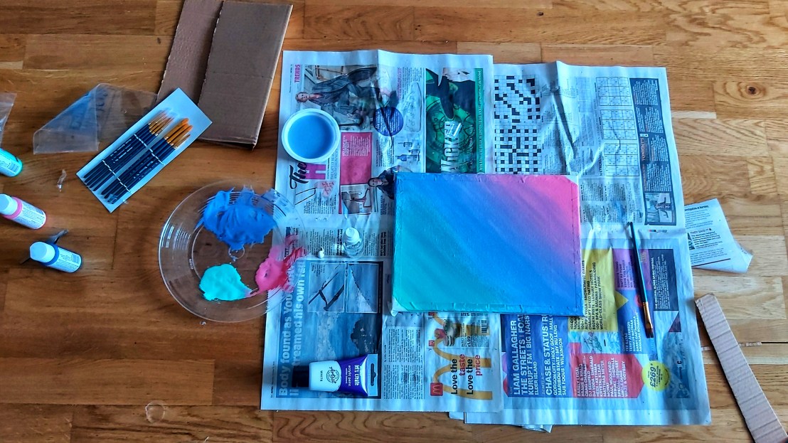 A canvas with gradient background painted with acrylics