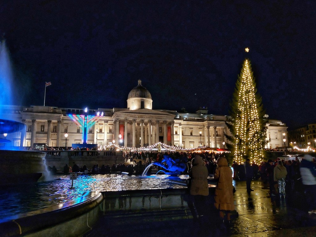 Trafalgar Square Christmas market and Christmas tree at night.