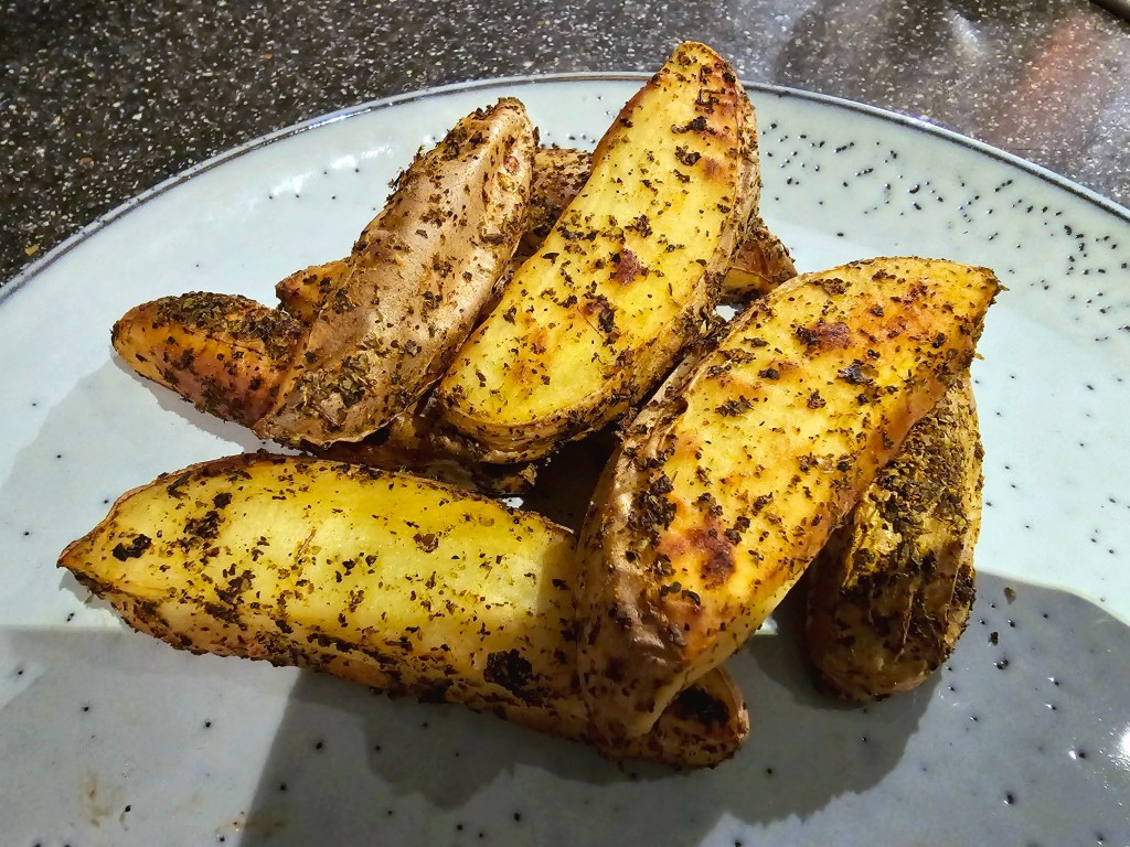 Air fried, seasoned potato wedges on a blue dinner plate.