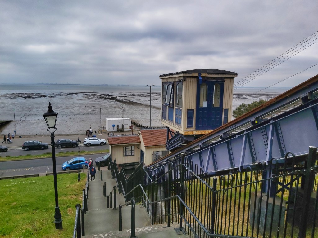 Cliff lift funicular in Southend-on-Sea. View from the top of the hill. Low tide sea visible on the horizon.