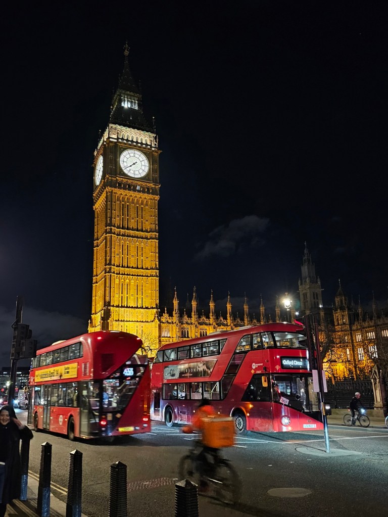 London Big Ben at night. Two red double-decker busses.