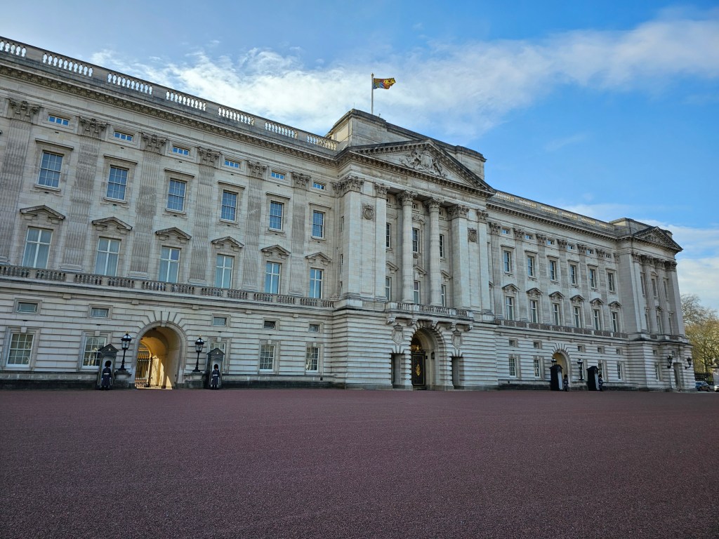 Buckingham Palace with the Royal Standard flag on the mast, indicating that the King is present at the Palace.