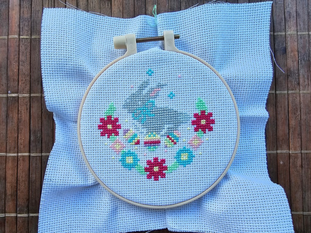 Partially completed Easter Bunny cross stitch project on a white aida, in a hoop.