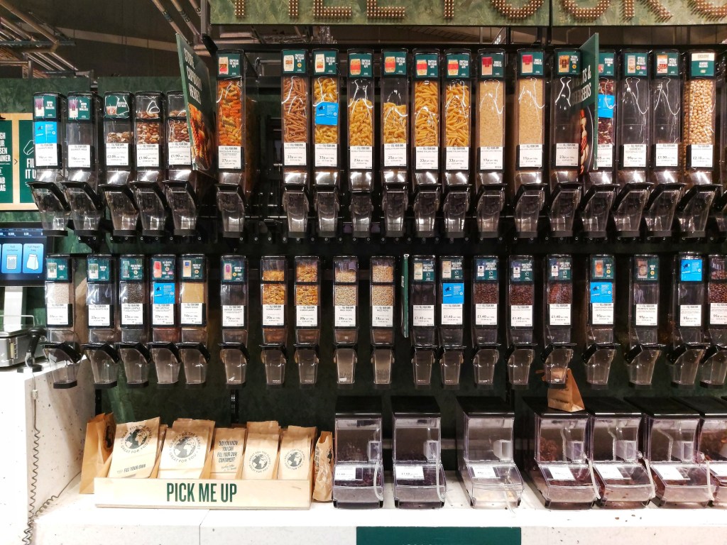 Loose food items in M&S store in England. Containers full of pasta, rice, dried fruits and nuts sold by weight.