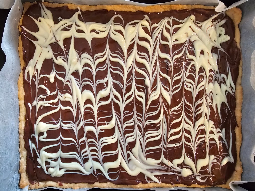 Bird's view of Polish Easter Cake - chocolate Mazurek. Thin shortbread base covered with dark and white melted chocolate.