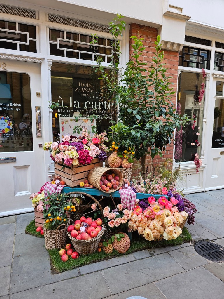 A colourful display of fresh flowers and fruits in front of a shop in Chelsea, London.