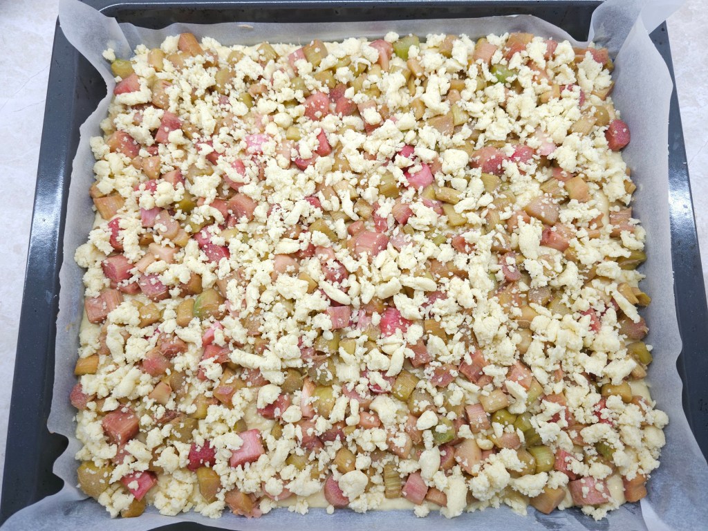 A sheet of rhubarb and crumble cake ready to go in the oven.