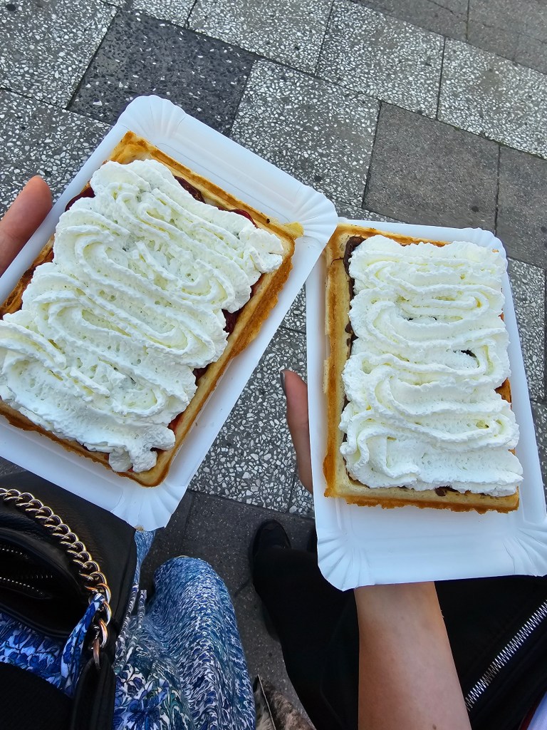 Two fresh waffles with whipped cream.