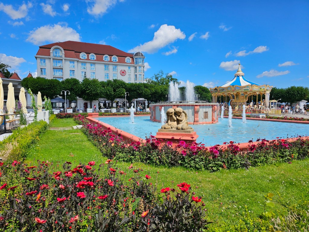 The centre of Sopot - a garden with green grass, flowers and a fountain.