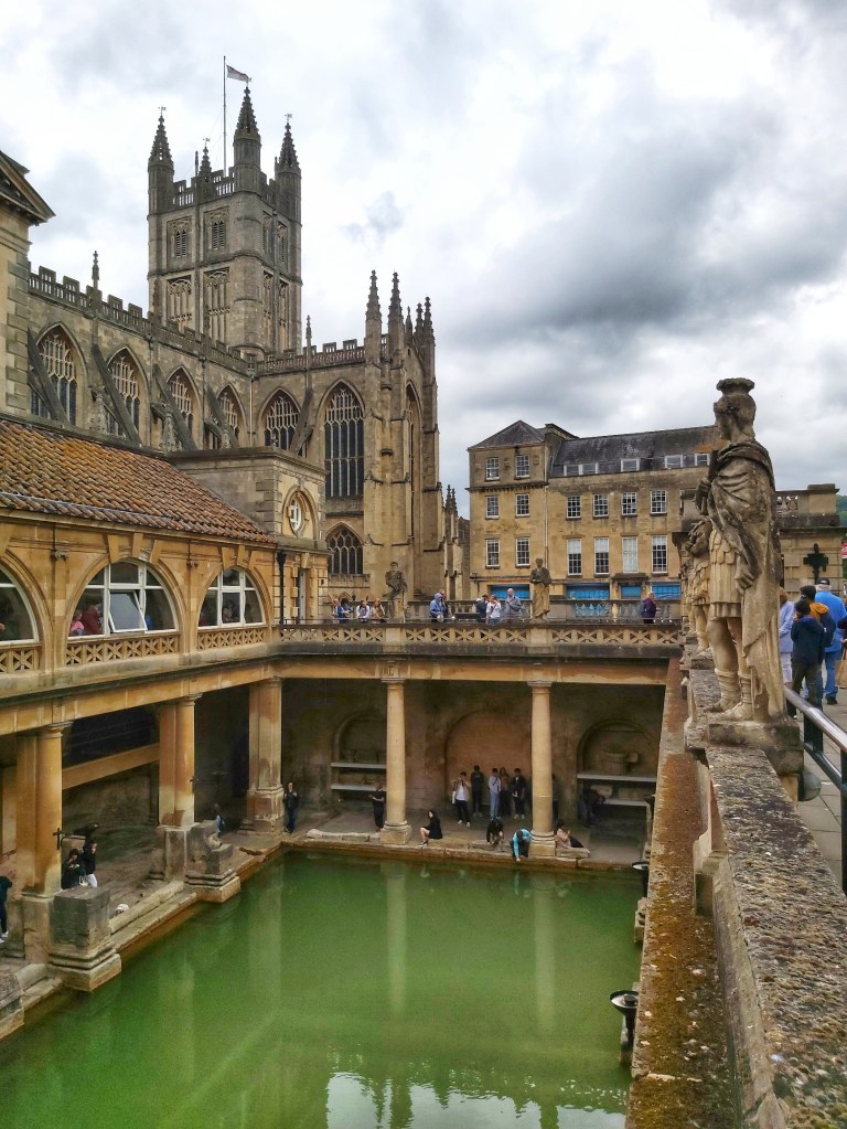 Characteristic green water in the Roman Baths in Bath, England. You can see the tower of Bath Abbey in the background.