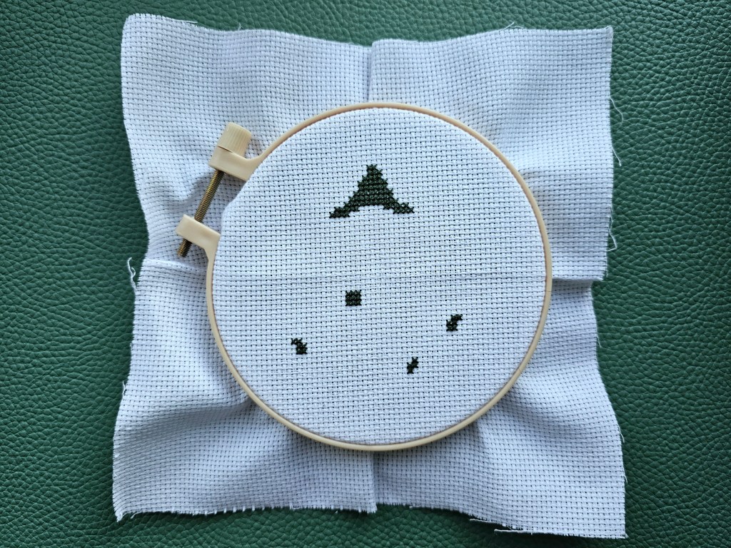 First steps as completing the Halloween cross stitch scarecrow design. The scarecrow's green hat as well as the green pumpkin stems are finished.