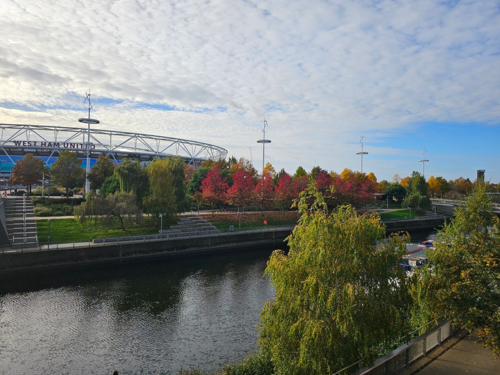 A row of red trees next to the West Ham United Stadion in London.