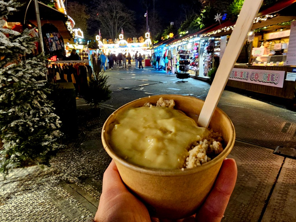 A pot of hot apple crumble with custard.