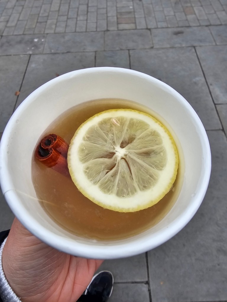 A hot toddy with a slice of lemon and a cinnamon stick, bought at Canterbury Christmas market.