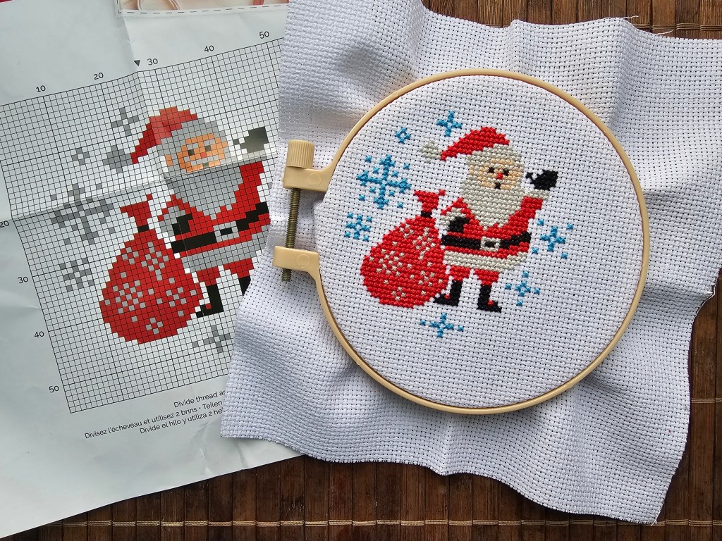 Completed mini cross stitch design featuring Santa Claus and snowflakes