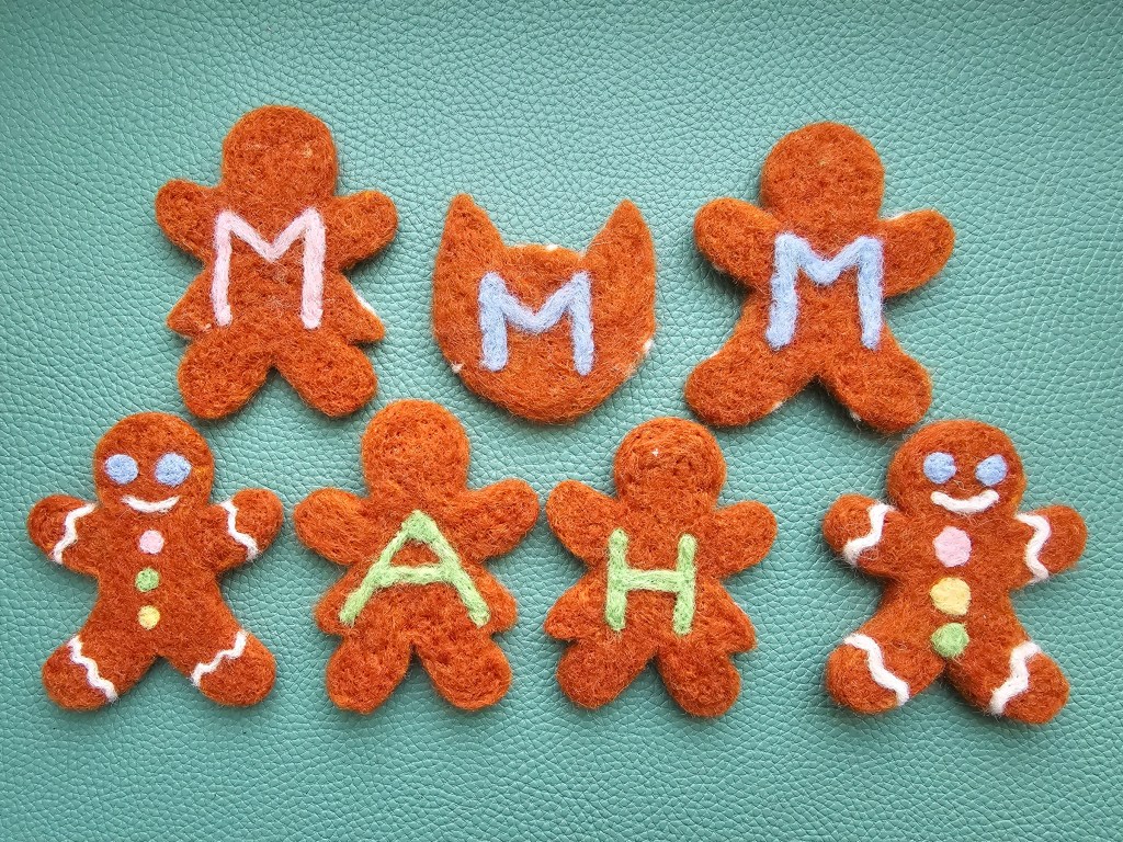 Finished felt gingerbread gift tags made with needle felting. The gift tags have initials at the back.