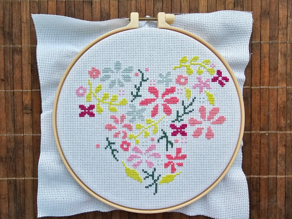 Nearly completed floral heart cross stitch design.