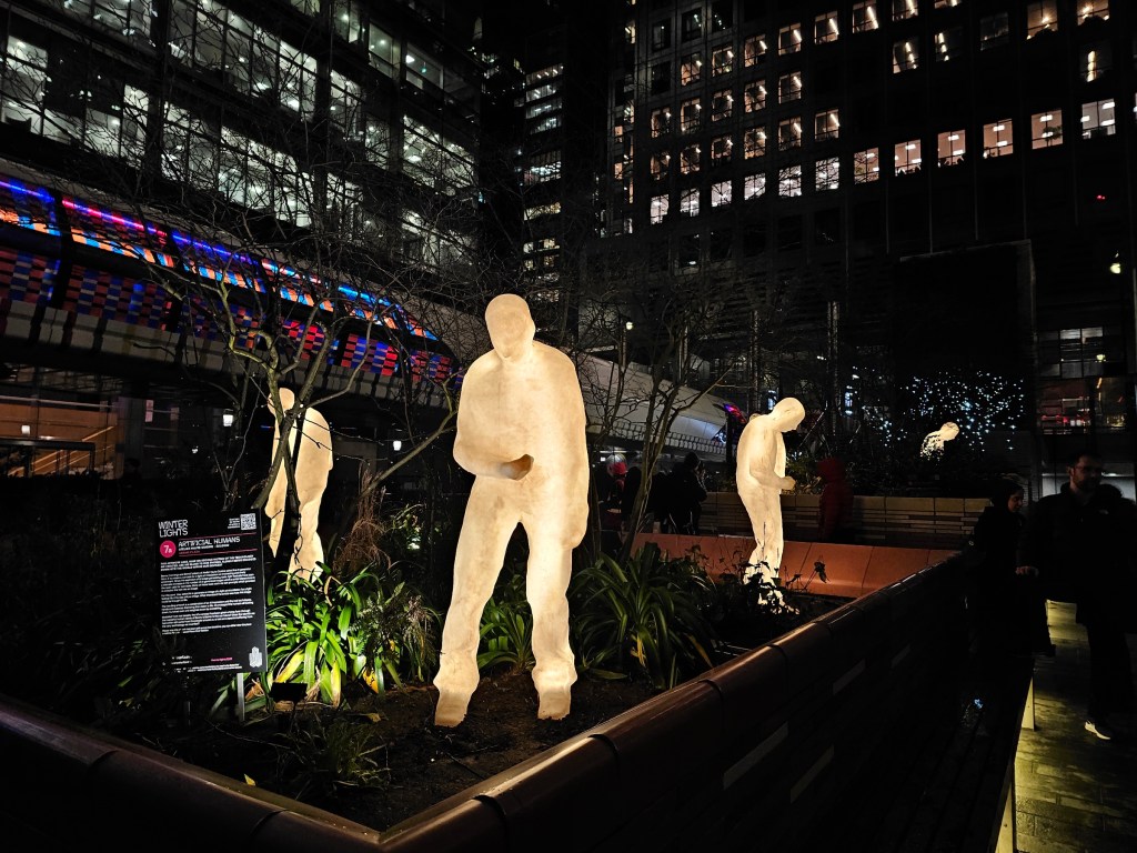 Life-sized sculptures in the shape of illuminated human statues.