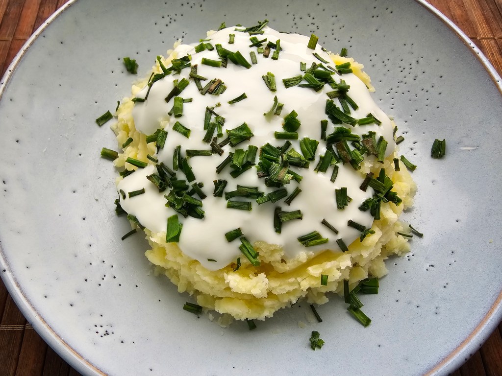 Mashed potatoes with kefir and chives, on a blue plate.